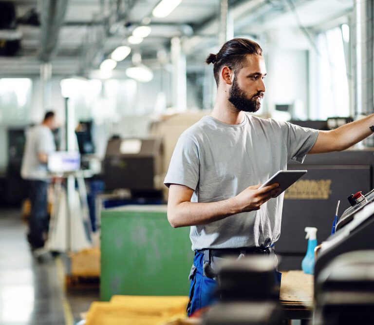 industrial-engineer-using-touchpad-while-operating-cnc-machine-factory